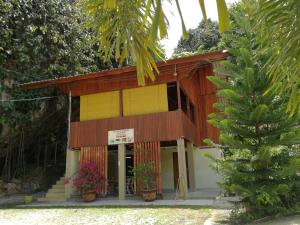 a small building with a yellow and brown at Country house Pulai Holiday Village in Gua Musang