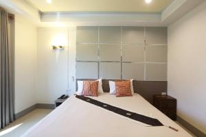 a bedroom with a large white bed with pillows at V Place Residence in Songkhla