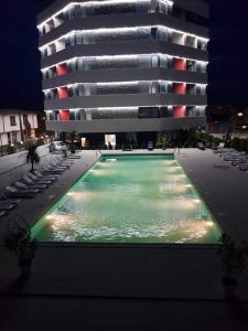 ein Schwimmbad vor einem Gebäude in der Nacht in der Unterkunft Apartament Unique Relax in Mamaia Nord – Năvodari