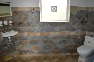 a bathroom with a toilet and a sink at Hotel At The End Of The Universe in Nagarkot