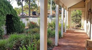 a porch of a house with a white fence at Tillbrook Cottage in Perth