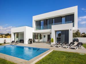uma grande casa branca com uma piscina em frente em Clem em Calpe