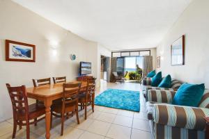 a living room with a table and chairs and a couch at Shandelle Apartments in Alexandra Headland