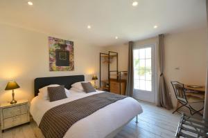1 dormitorio con cama, escritorio y ventana en chambres d hotes Le Mas Julien piscine chauffée adult only, en Orange