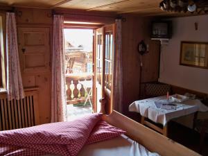 ein Zimmer mit einem Bett und einem Tisch und einem Fenster in der Unterkunft Gästehaus Bichl in Umhausen