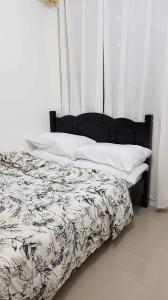 een bed met een zwart-wit dekbed en kussens bij 1 Bedroom Apartment @SMDC Shore Residences, Mall of Asia in Manilla