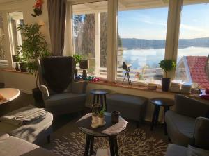 a living room with a large window with a view of the water at Lovely studio apartment seaview & private sauna in Lerum