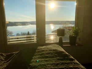 a bedroom with a large window with a view of the water at Lovely studio apartment seaview & private sauna in Lerum