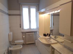 a bathroom with a sink and a toilet and a window at Alloggio Primosole in Fossano