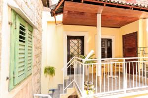 a house with a balcony with a wooden door at Apartments Kovacic_Grubisic in Split