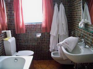ein Badezimmer mit einem weißen Waschbecken und einer Toilette in der Unterkunft Gästehaus Bichl in Umhausen