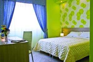 um quarto com uma cama, uma secretária e uma janela em B&B Albachiara em San Leone