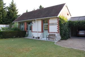 ein kleines Gebäude mit einer Bank im Hof in der Unterkunft aux coeurs de l'atelier in Menars