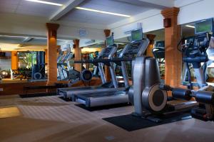 - une salle de sport avec plusieurs tapis de course et appareils de cardio-training dans l'établissement Tandjung Sari Hotel, à anur