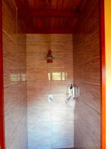 y baño con ducha y pared de madera. en Korovesi Sunshine Villas en Savusavu