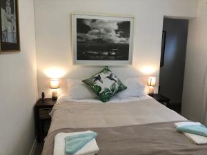 a bedroom with a large bed with two lamps at The Speckled Egg, 4 Promenade Rd, Lakeside, Cape Town in Cape Town +40 photos