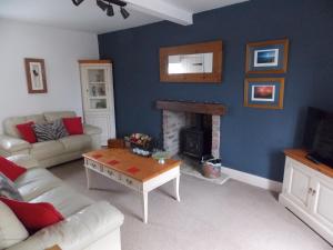 a living room with a couch and a fireplace at Hilltop Cottage, Barnard Castle in Barnard Castle