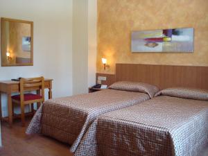 a hotel room with two beds and a table at Hotel Castilla in Albacete