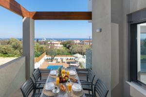 a table on a balcony with a view of the ocean at Terpsis Pool Villa in Rhodes Town
