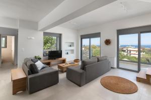 a living room with two couches and a television at Terpsis Pool Villa in Rhodes Town