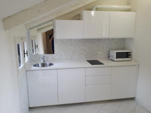 een witte keuken met een wastafel en een magnetron bij Casanova Apartment San Marco in Venetië
