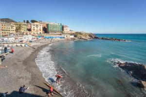 a group of people standing on a beach with surfboards at house LeoMar di Maria in Genova