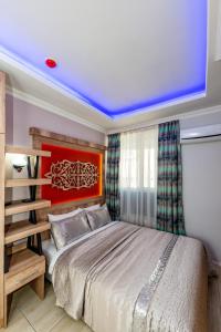 a bedroom with a large bed with a red headboard at Linda Expo Palace in Antalya