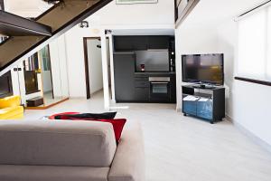 uma sala de estar com um sofá e uma televisão de ecrã plano em Erida Apartment - Piazza di Spagna em Roma