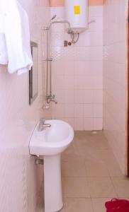 a white bathroom with a sink and a shower at Cityview Hotel Fort Portal in Fort Portal