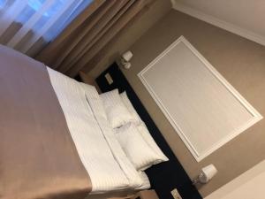 a bed in a room with white sheets and pillows at Benefit Boutique Hotel in Odesa +96 photos
