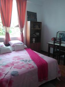 a bedroom with a bed with red curtains and a window at VILLA ARIANNA in Wattala +114 photos