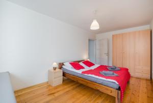 una camera da letto con un letto con lenzuola rosse e cuscini rossi di Hello Apartments Złota Brama - Old Town a Danzica