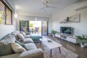 een woonkamer met een bank en een tv bij ZEN QUEST - The NOMADS PAD Near Nightcliff Markets & Sunset Foreshore in Nightcliff