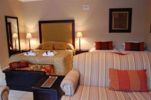 ein Hotelzimmer mit 2 Betten und einem Sofa in der Unterkunft Branley Lodge Bed and Breakfast in Hillcrest
