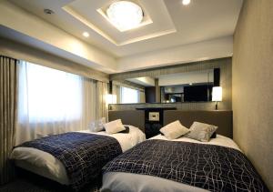 a hotel room with two beds and two lamps at APA Hotel Ueno Inaricho Ekikita in Tokyo