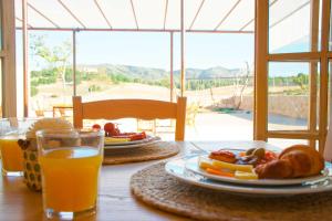 una mesa con un plato de comida y un vaso de zumo de naranja en Ca Na Nina, en Sant Llorenç des Cardassar