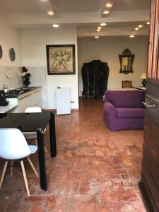 a living room with a purple couch and a table at La Stalla in Tuscania