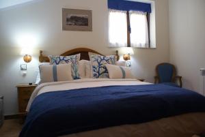a bedroom with a large bed with blue and white pillows at Casa Rural Priena in Covadonga
