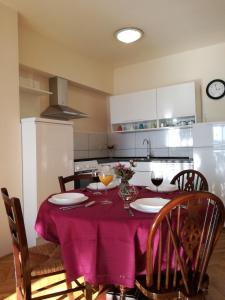cocina con mesa y mantel púrpura en Apartman Una, en Crikvenica