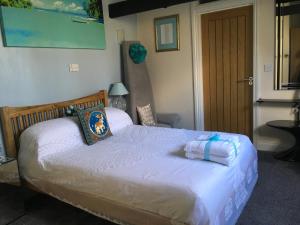 Cherrywood Lodge في لوي: غرفة نوم بها سرير مع مناشف عليه