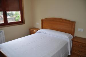 ein Schlafzimmer mit einem weißen Bett und einem Fenster in der Unterkunft PISO MARENTES in O Grove