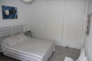 - une chambre avec un lit aux murs blancs dans l'établissement Face à la mer Résidence Les Elmes, à Banyuls-sur-Mer