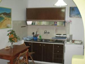 una pequeña cocina con fregadero y una mesa con una mesa. en Vesuvio Chora en Ios Chora
