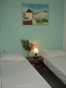 2 camas en una habitación con una foto en la pared en Vesuvio Chora en Ios Chora
