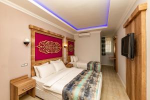 a hotel room with two beds and a flat screen tv at Linda Expo Palace in Antalya