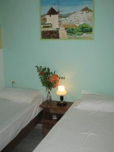 a bedroom with two beds and a table with a lamp at Vesuvio Chora in Ios Chora