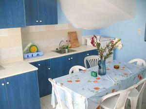 una cocina azul con una mesa con un jarrón de flores. en Vesuvio Chora, en Ios Chora