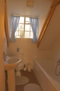 a bathroom with a sink toilet and a window at Hillside Cottage in Clarens