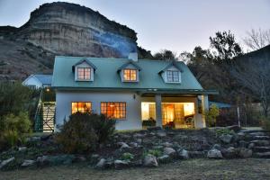 a house with a mountain in the background at Hillside Cottage in Clarens