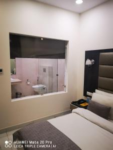 Schlafzimmer mit einem großen Fenster und einer Badewanne in der Unterkunft Hotel PK Residency in Noida